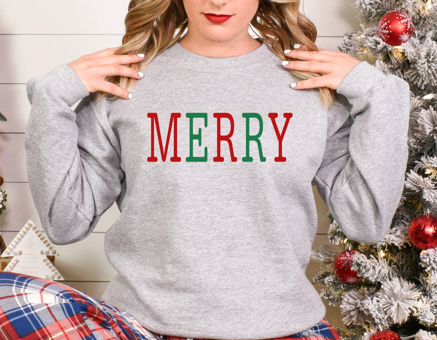 Merry red and green text on a grey unisex crewneck sweatshirt