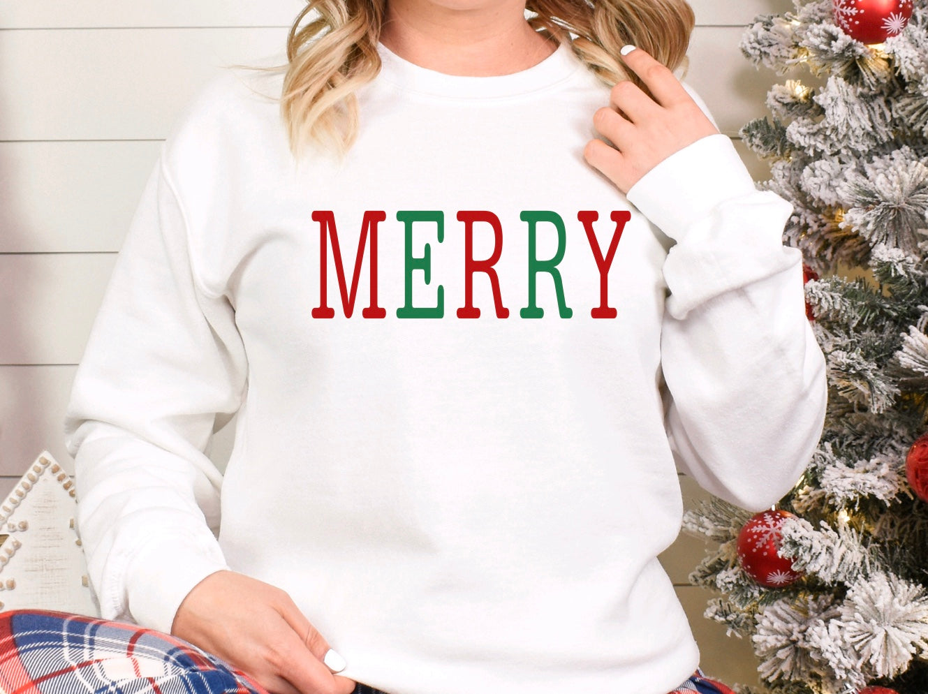 Merry red and green text on a white unisex crewneck sweatshirt