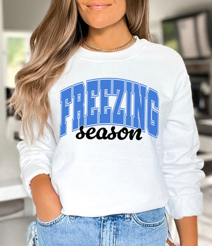 Freezing season unisex Gildan hoodie or crewneck sweatshirt in white with blue and black lettering 